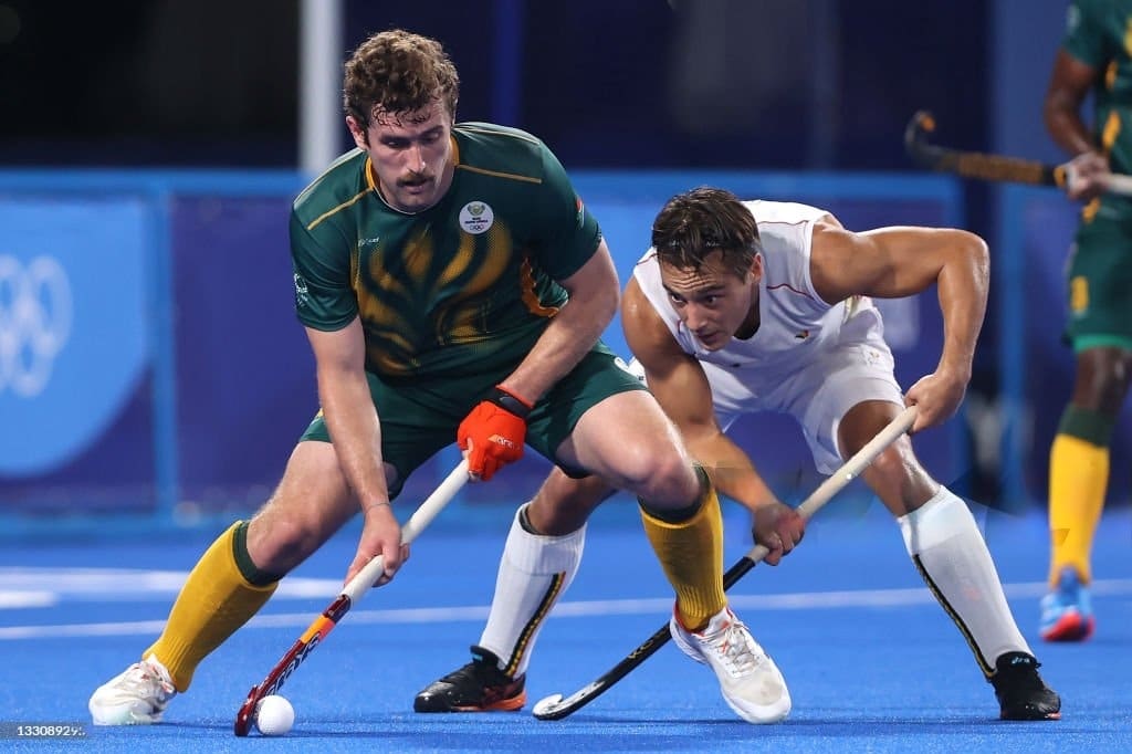 two hocky players trying to goal and snatch ball from each other on the field