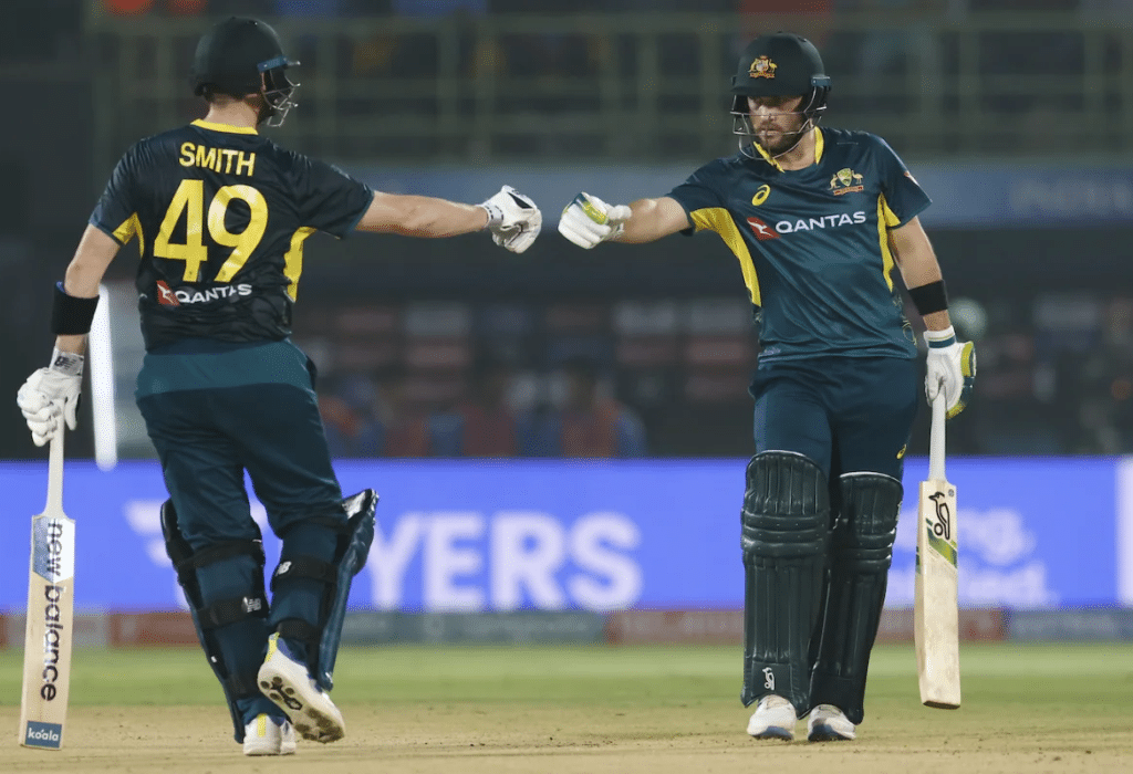 Steven Smith and Josh Inglis fist shake during a match standing in the stadium