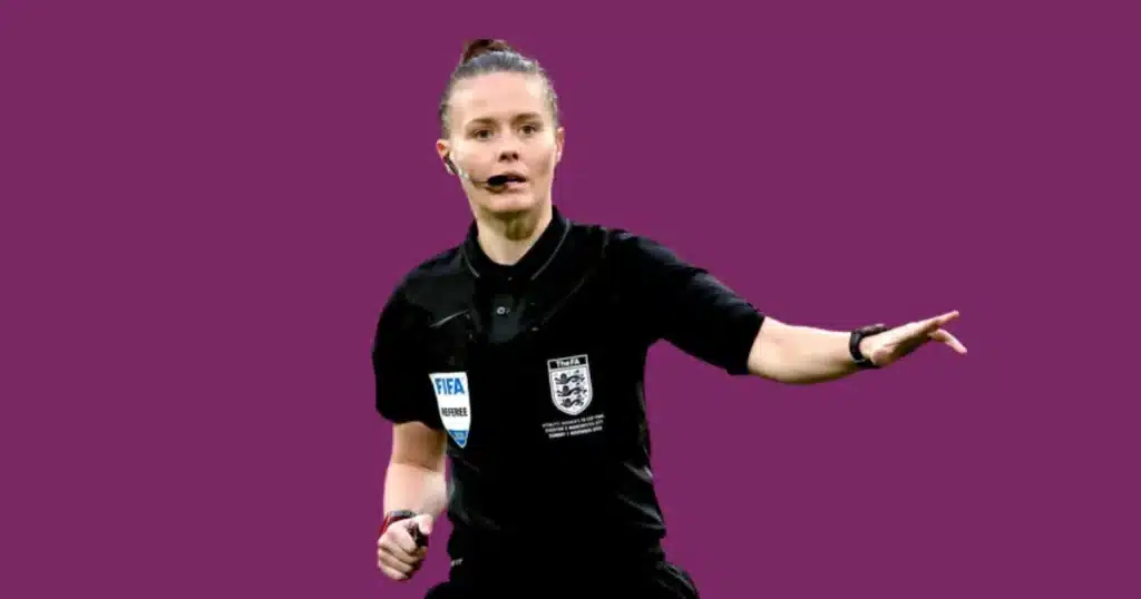 Rebecca Welch pointing in the field of football while she is referee of the match in black trouser shirt